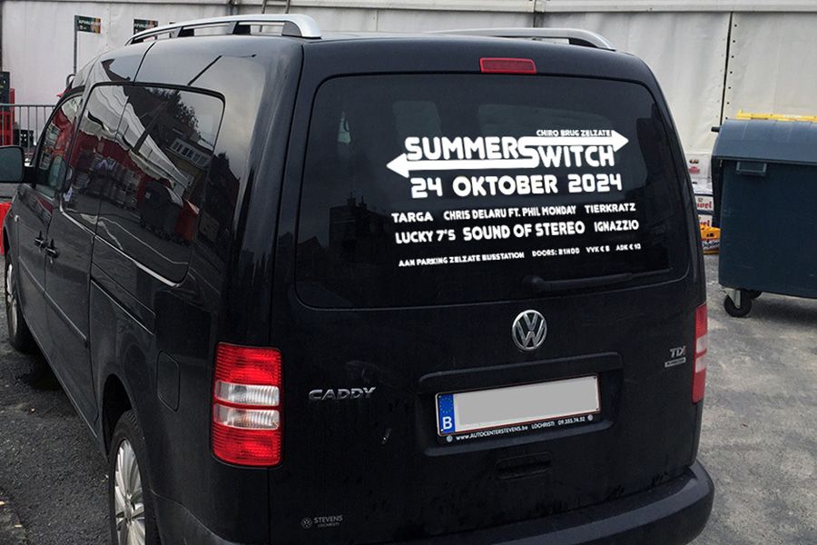 plakletters als tijdelijke reclame op de achterruit van een bestelwagen